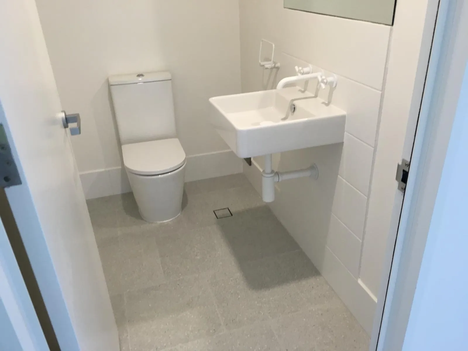 Powder room with grab rails, a wall-mounted basin and tiled flooring
