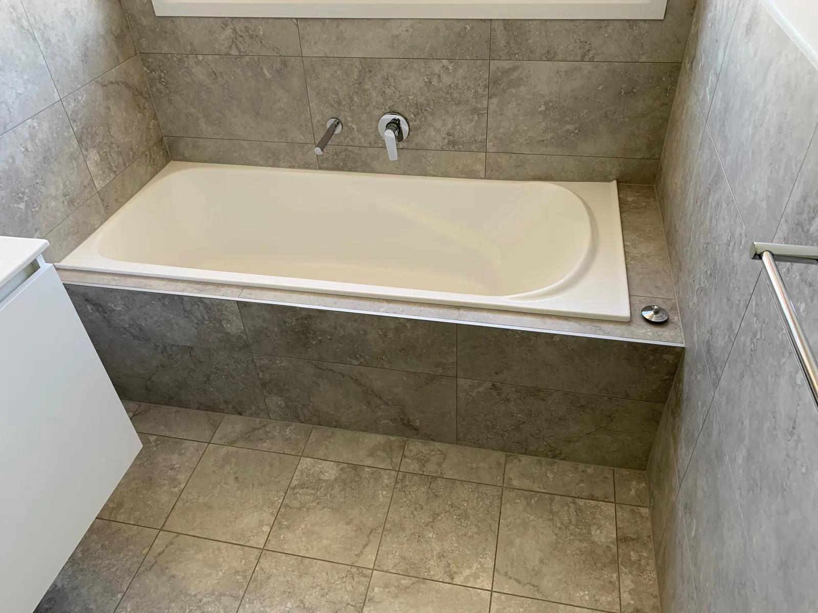 Built-in bathtub with stone-look wall tiles
