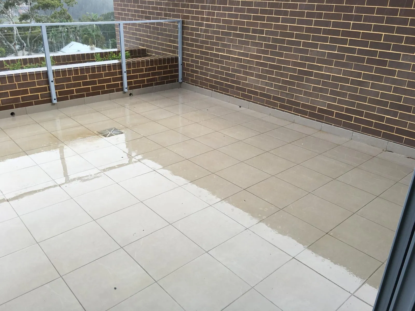 Pale tiled courtyard bordered by brick walls