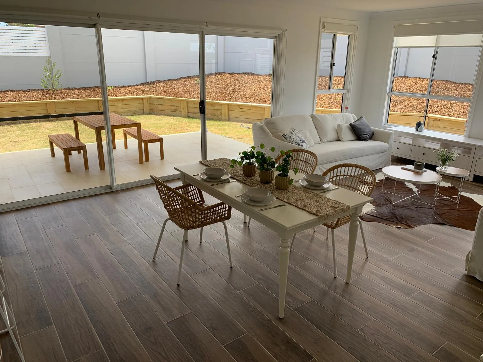 Open-plan living and dining area with timber-look tiles and large windows